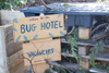 A handmade sign which reads 'Welcome to the bug hotel. Vacancies. All creatures welcome'